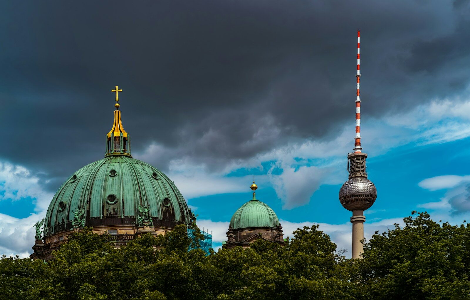 Berlin cathedral and television tower against dramatic skies.